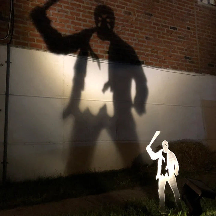 Metalowy palik ogrodowy z cieniem złoczyńcy na Halloween i reflektorem wyświetlającym projekcję